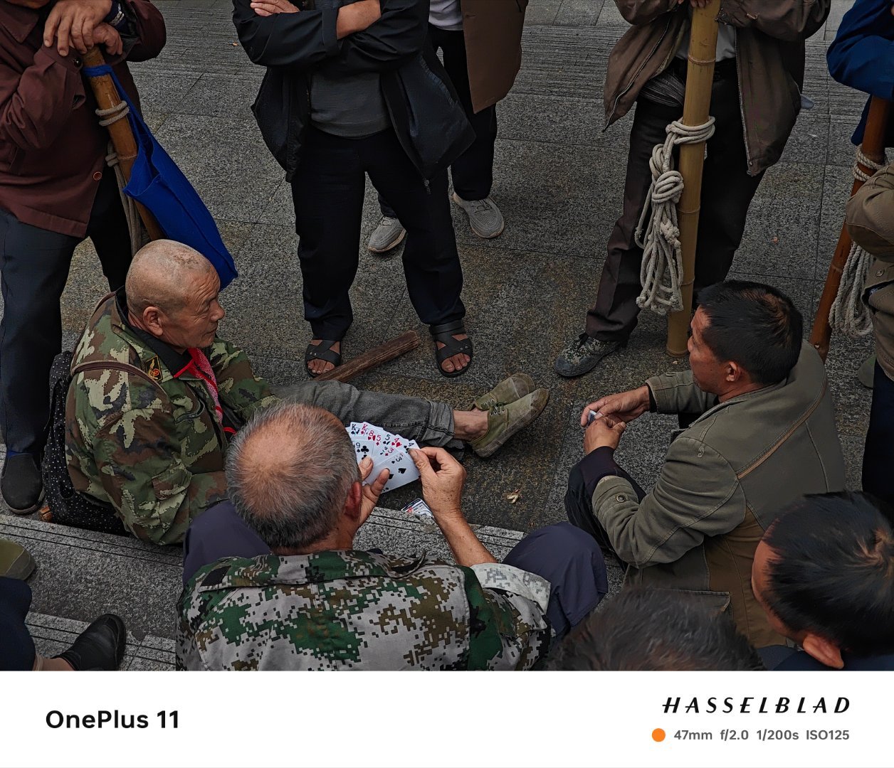 劳作之余，棒棒们聚在一起打牌，享受难得的休闲时刻。他们用笑声和牌局暂时忘却生活的