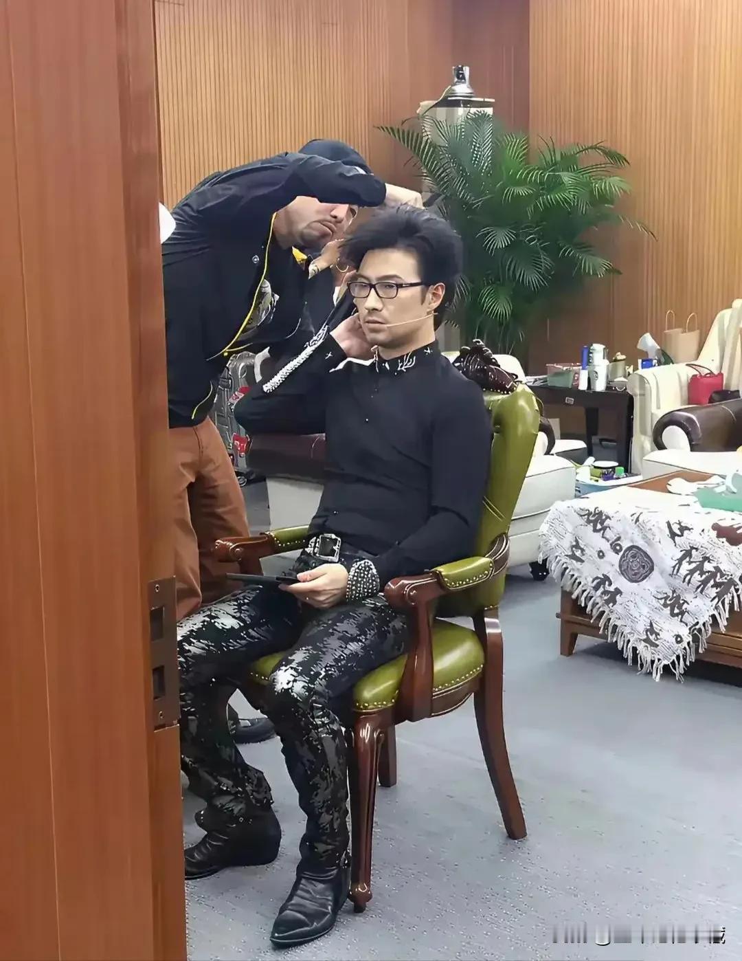 汪峰在补妆容的老照片，化妆造型师在给汪峰做造型，汪峰这身装扮太花哨了，尤其这条蛇