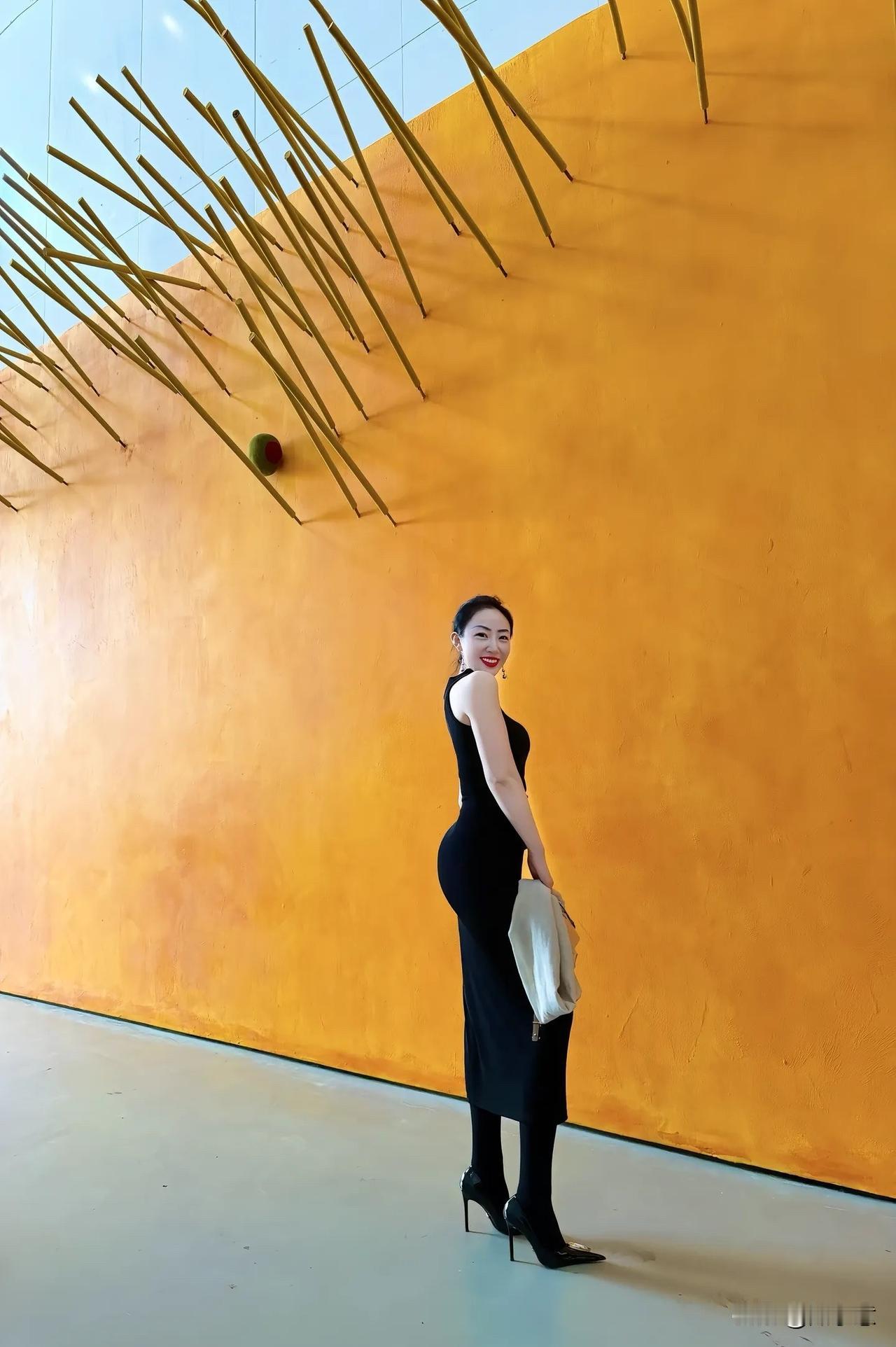 优雅黑裙与明黄色背景的完美碰撞，尽显时尚魅力！💃🏻✨