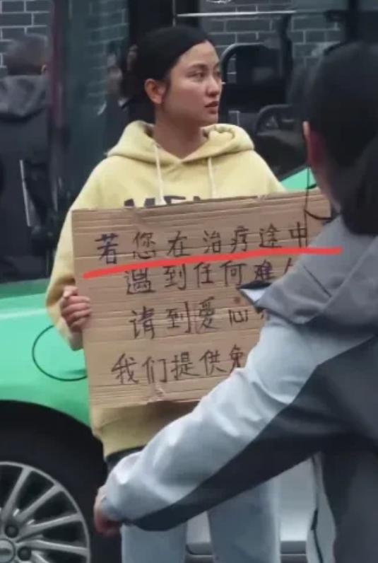 四川成都，华西医院门口有一个女孩子胸前举着一块牌子，写着提供免费住宿吃饭，很多人
