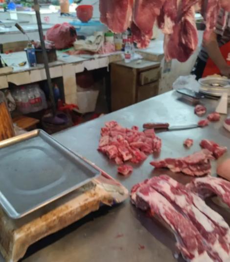女顾客在菜市场挑中一块排骨，称重后直接付了96元。摊主刚举刀准备剁，她便表示不用