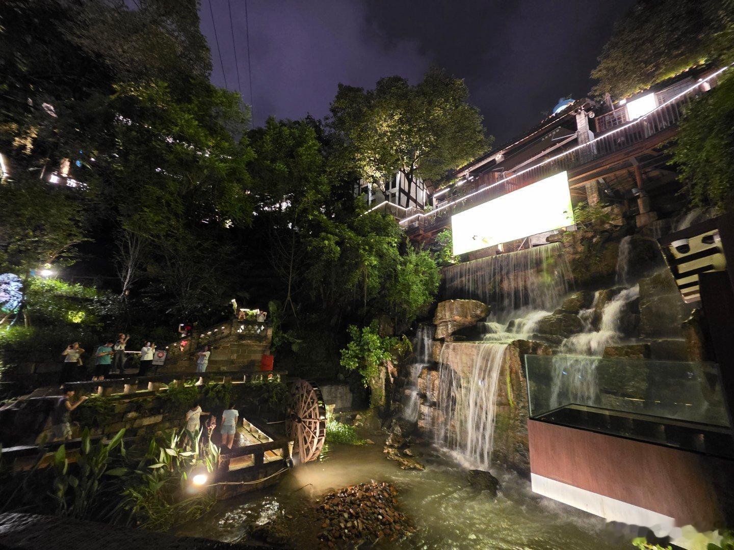 夜探重庆下浩里，与白天完全不一样的风景。特别是山涧下来的瀑布，在摇曳的灯光下，让