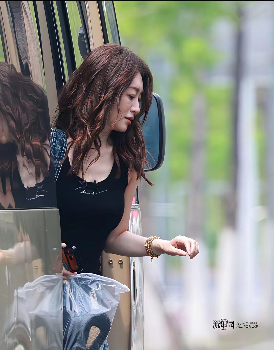 刷到今日上班的李小冉，即将50岁的她简直逆生长，黑色吊带背心+牛仔裤、牛仔包，标