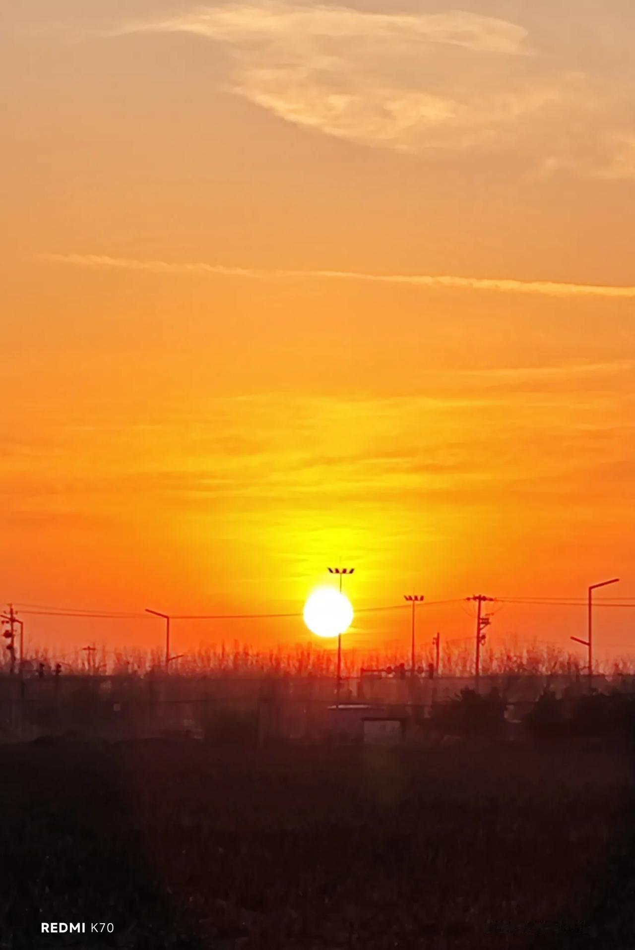 11月18日晨，旭日东升刚出东方天际线，明月西下仍然挂在西边的高空中，日月同框，