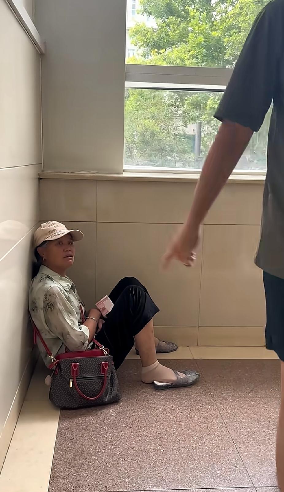 一名女子愁容满面地独自坐在墙角，陌生男子突然做出的一个举动，让人看着瞬间感动落泪