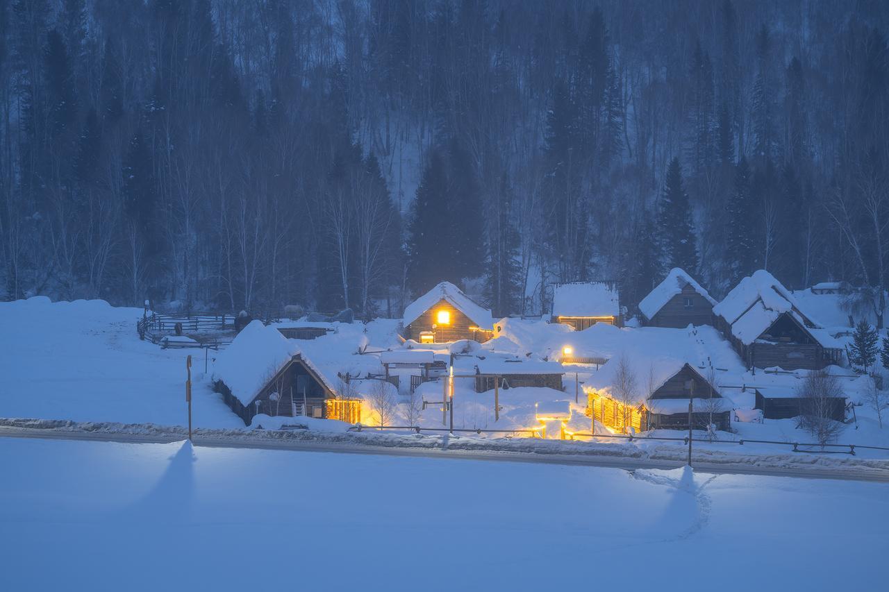 冬天的禾木村，厚厚的积雪盖住了屋顶和地面，让整个场景都非常的干净。蓝调时刻环境变