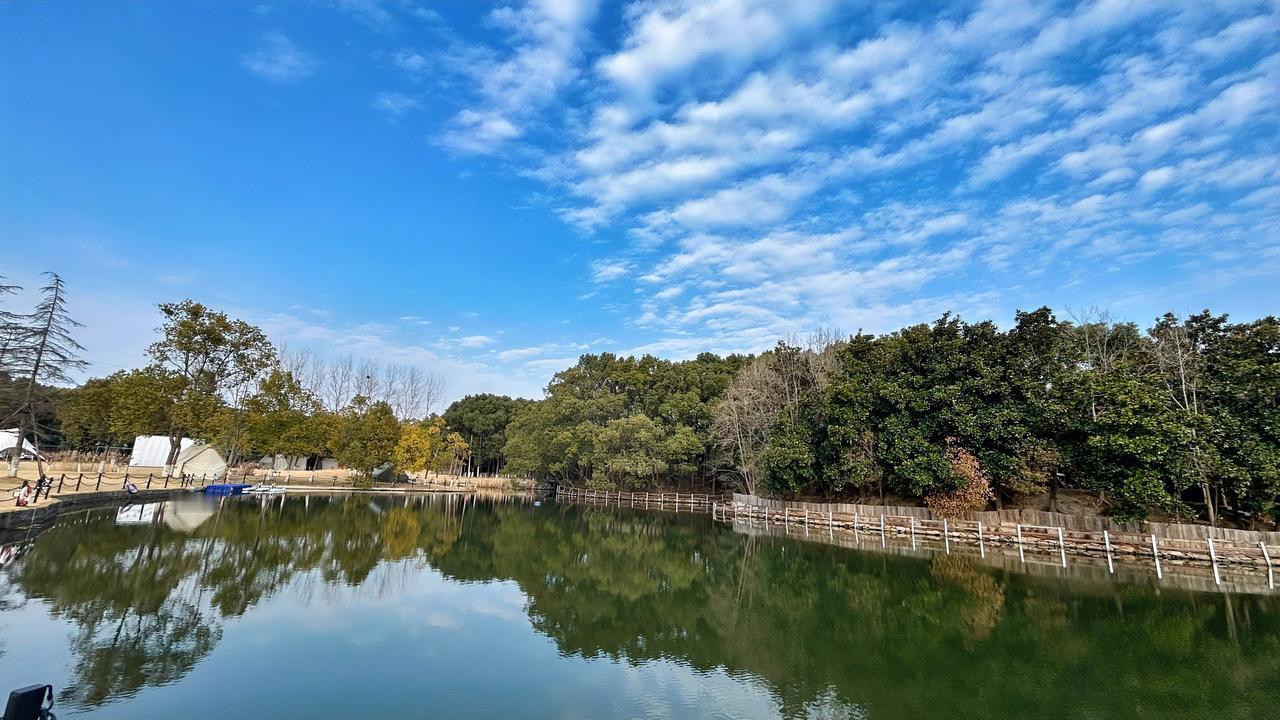 随手拍张天空照蔚蓝的天空，白云朵朵，静谧而深邃。清沏的湖面，倒映着湖边绿树的一排
