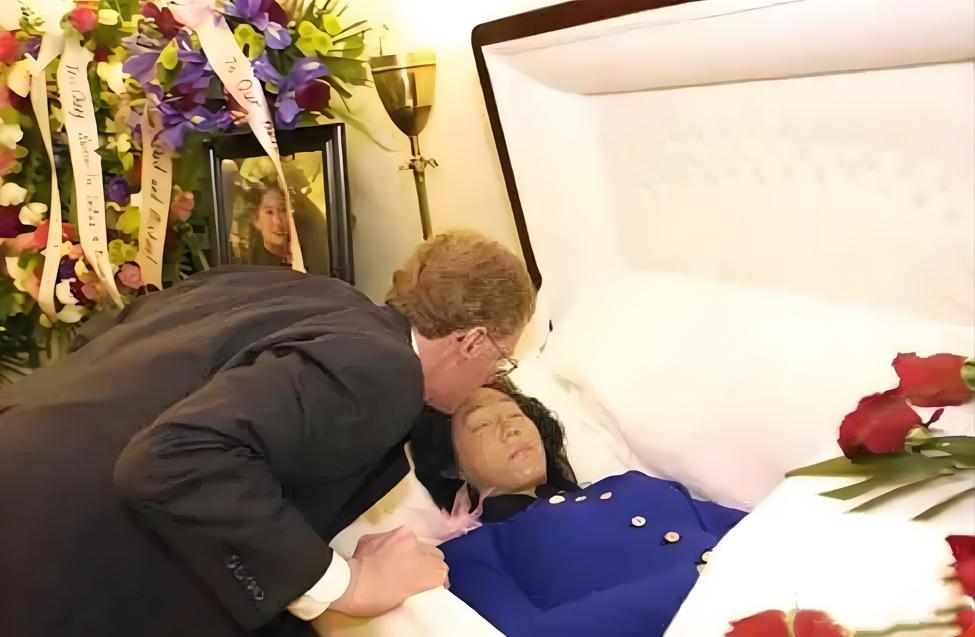 这是张纯如最后的遗容，她安详地躺在棺椁里，丈夫亲吻她的额头，与她做最后的告别，她