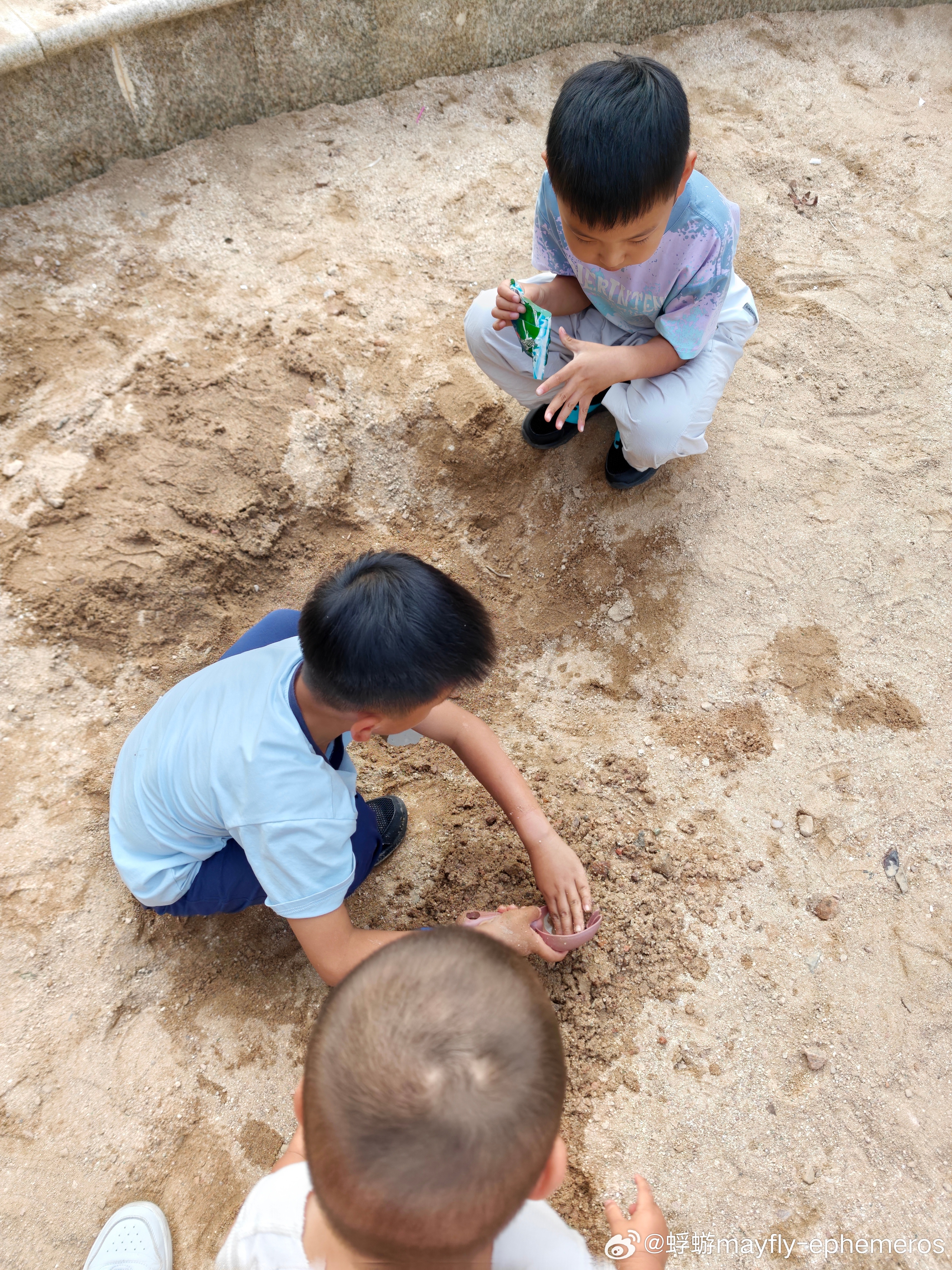 大小孩挖沙坑挖到了水另一个说哇！！你挖出了地下水？笑笑也跟着哇……后面的话不会说