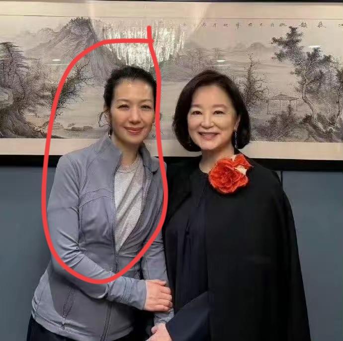 两位女士一起在墙前合影，笑容灿烂。左边的是演员吗？是哪一位？有认识的吗？[作揖]