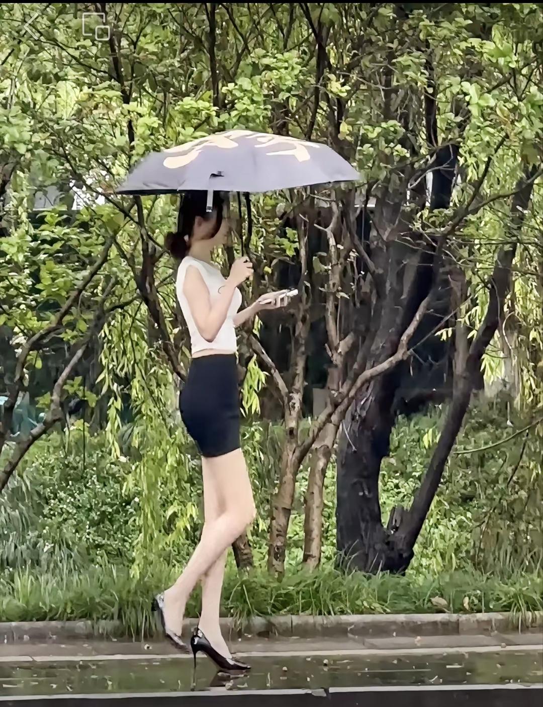  雨天公园是一道美丽的风景，而雨中打伞漫步的美女更是增添了靓丽的颜色，没有人在乎