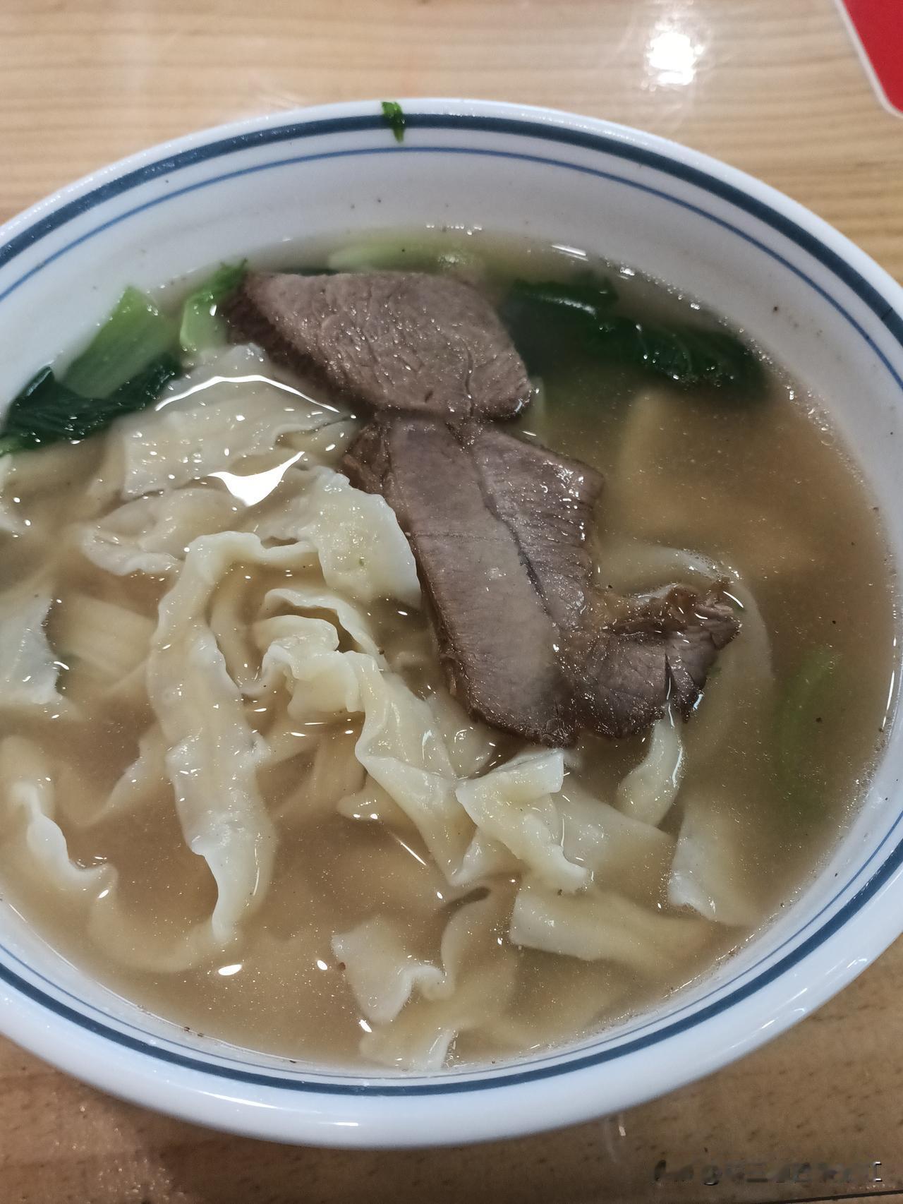哈尔滨东站附近，有家小吃部18元一碗的红烧牛肉面，几颗油菜，两片薄薄的牛肉片。