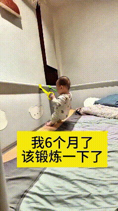 六个月的小宝宝也太自律啦，抓着围栏上的吊环来回拉扯锻炼，拉着吊环站起又坐下，动作