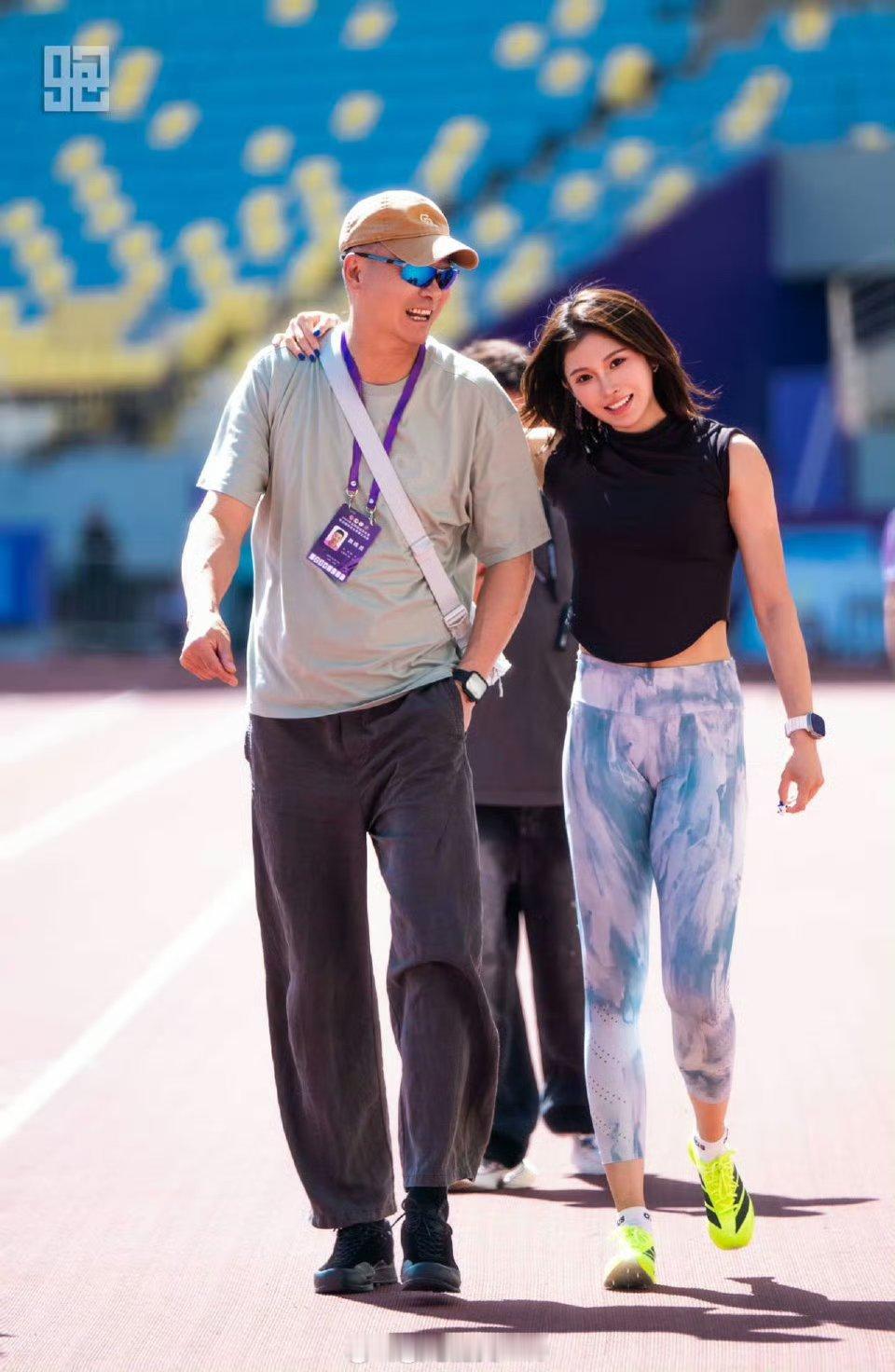 吴艳妮与教练合照：冠军领奖台上的欢快合影，吴艳妮与教练笑容灿烂，定格胜利时刻的共