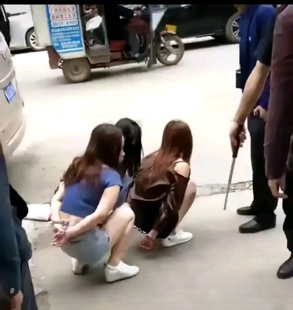 真的很同情三位小姐姐，
她们究竟做了什么错事，
竟然下蹲着还佩戴手铐，
旁边是手