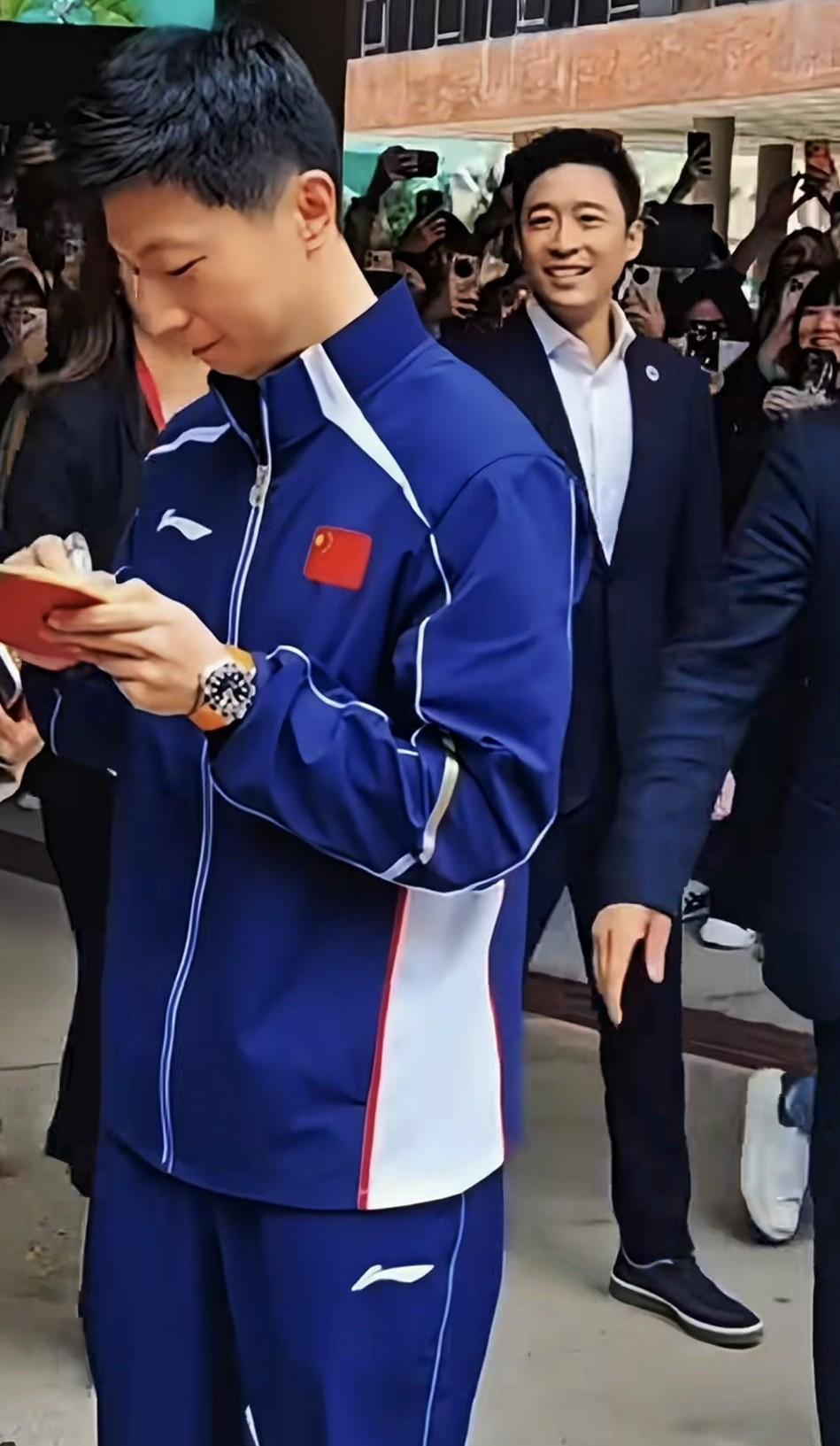 大家看出马龙背后走来的人是谁吗？看那个场面，他才是今天的焦点，多少人举着手机都是