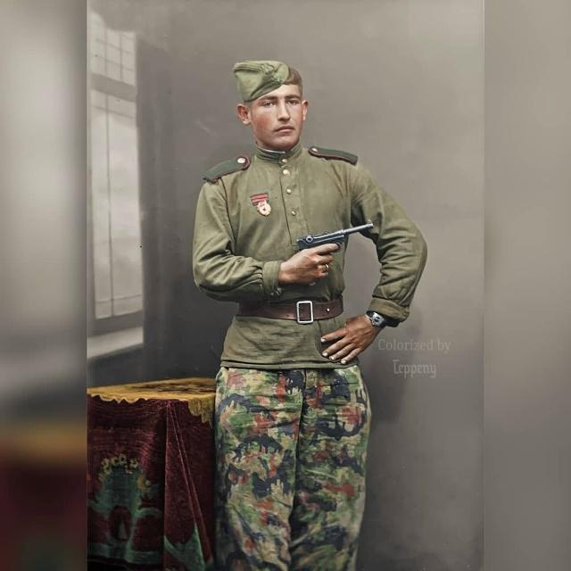 1945 年 5 月 5 日，一名苏联红军战士手持缴获的德军鲁格 P08 手枪（