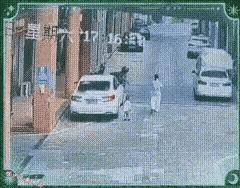 在马路中间走这个女子，是个极不负责任的妈妈，他带着小孩在马路中间行走，他只顾他自