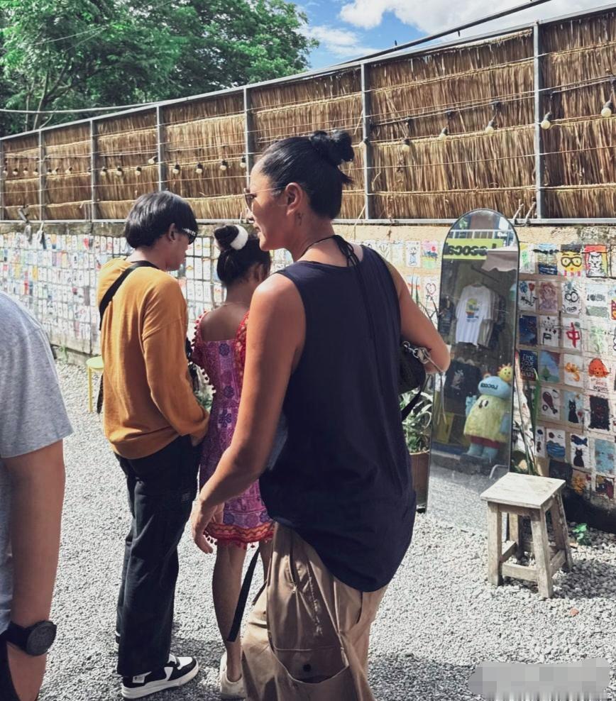 这组照片是网友在泰国清迈艺术村偶遇瞿颖时拍下的。
 54岁的瞿颖扎着利落丸子头，
