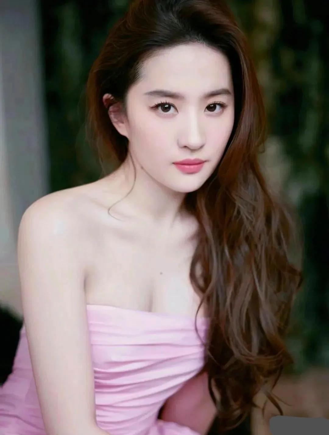 刘亦菲身着一袭流光溢彩的紫色礼服，宛如夜空中最亮的星。

这款礼服以其独特的剪裁