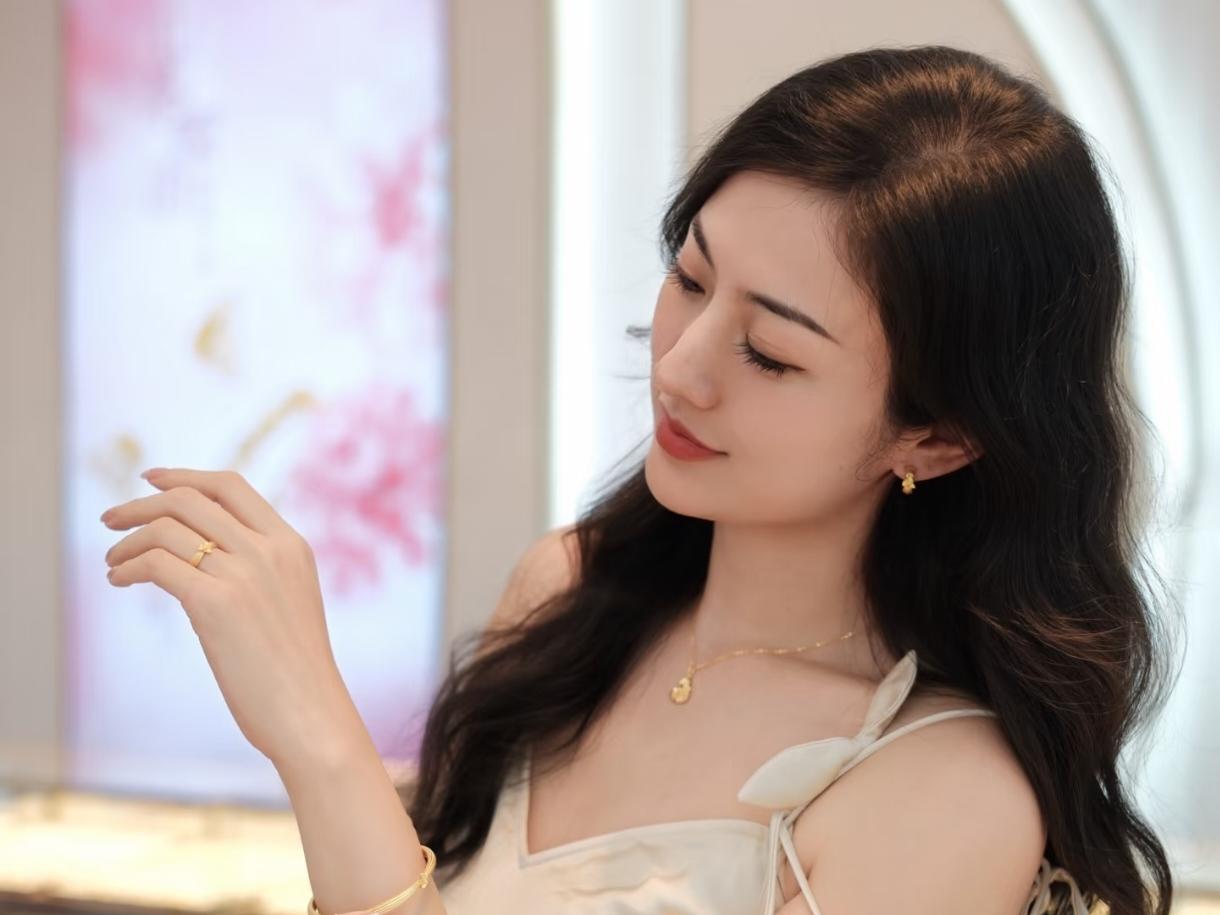 《临江仙·金饰映纱裙》
 
柔缎裁成云外色，裙肩叠作花轻。鬓边风软动春晴。镜中波