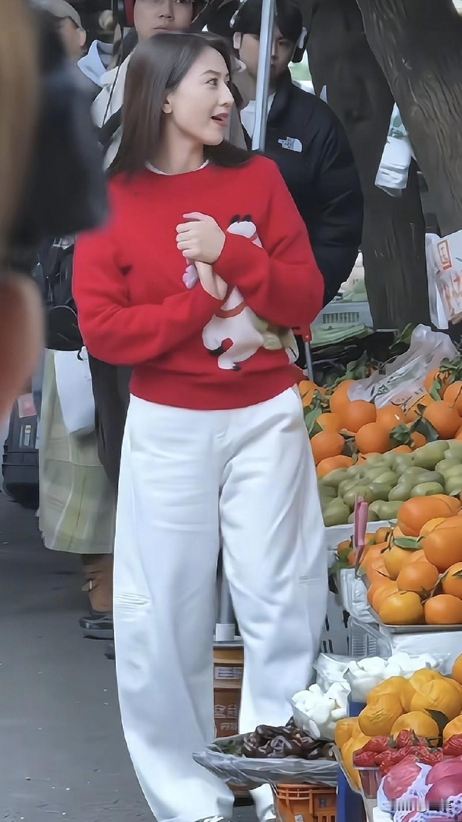 高圆圆，她穿着红色印有卡通小马的毛衣搭配白色休闲裤，笑容明媚又治愈。