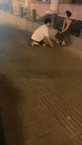 网友深夜在街头拍到一个年轻男孩不停的向一名女孩跪拜磕头？
也不知道他究竟是犯了什