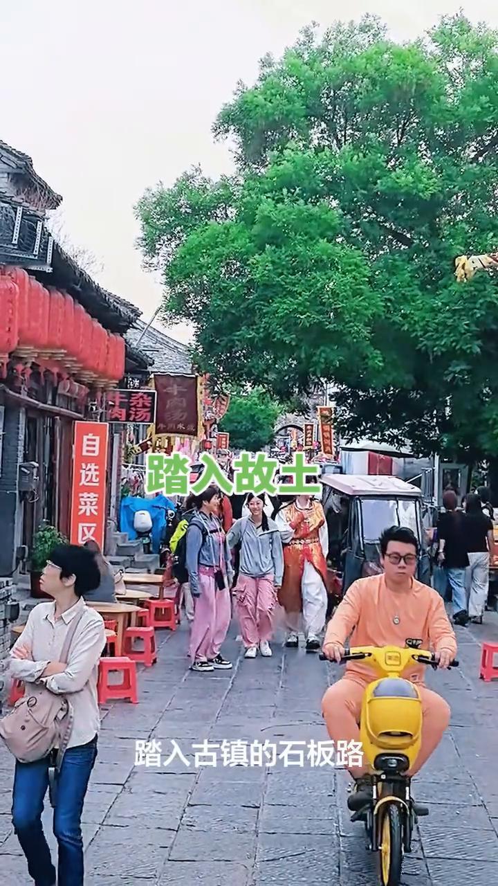 踏入故土。
踏入古镇的石板路，青苔蔓延岁月的纹路，斑驳的墙藏着旧时光，仿佛听见历