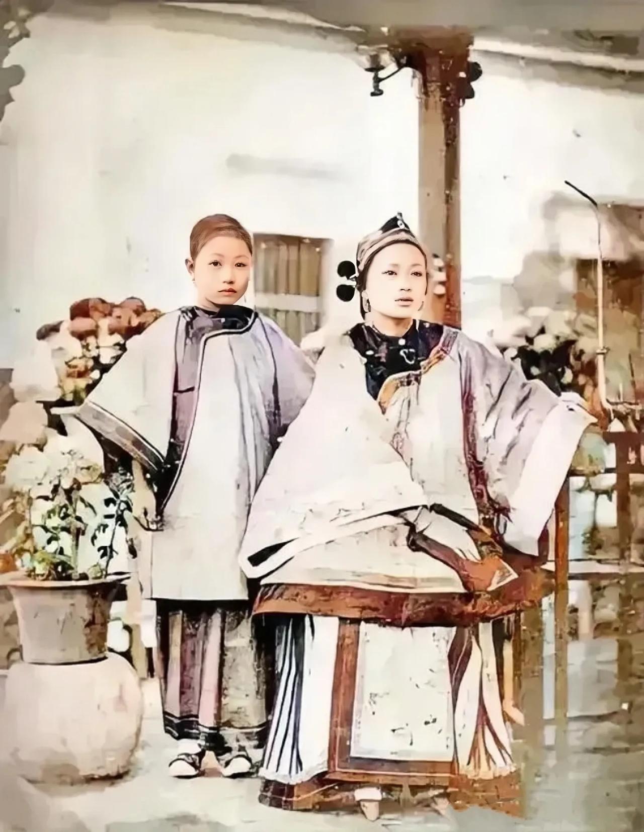 清末时期，一个大户人家的千金小姐和她的小丫鬟的一张合影。
这个富家千金小姐穿着宽