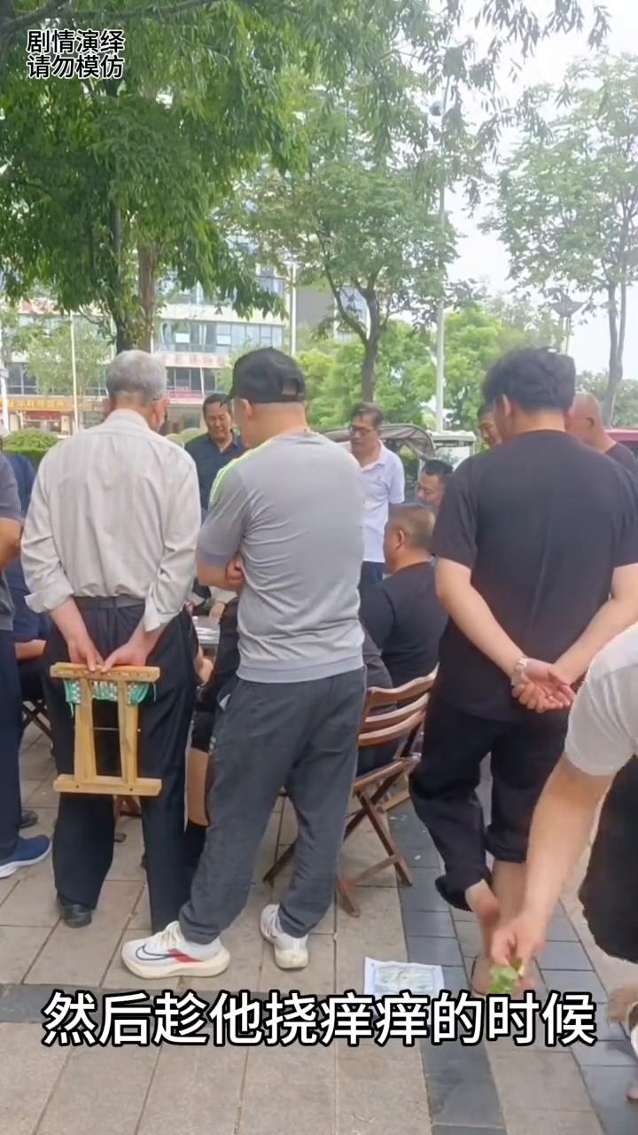 男子在看打牌时朋友在后面整蛊他，这一幕真的太搞笑了。
男子背着手在看别人打牌，这