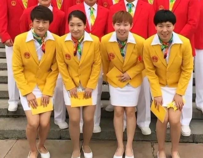 四位国乒巾帼，一身亮眼黄正装，笑容自信从容，尽显国乒巾帼风采，气场强大，荣耀在身