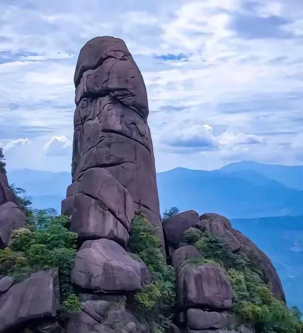 奇峰高耸入云霄，
岩壁千峰耸翠峦。
一根石柱突破天，
屹立山中千万年。
古往今来