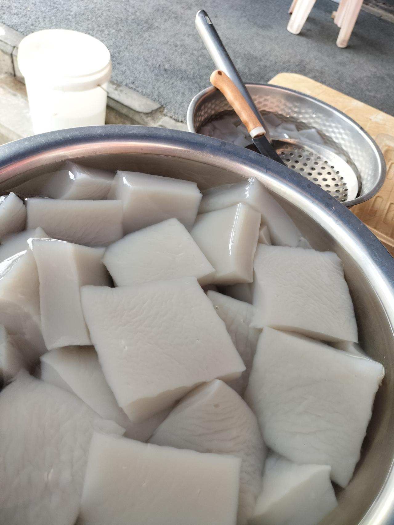 盆里白色的豆腐是我们万合特产：青豆腐，另一个盆里的是黑凉鞋，两种味道不一样，但很