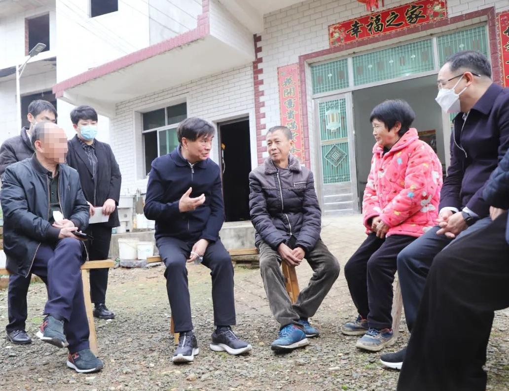 照片中这位坐在长板凳中间的老人，曾是江西省慈善总会的会长。他衣着简朴，脚穿一双普