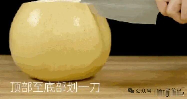 完整剥柚子双手反复揉捏柚子，让果皮和果肉松动，切掉柚子顶端一小截果皮，用勺子贴着