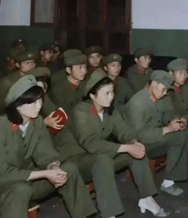 看到一张老照片，一群军人身着65式军服，坐在俱乐部或会议室里，正在参加集体活动，
