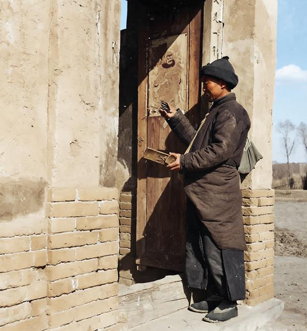 1933-1946年间，海达·莫里循镜头下，砖石砌成的门楼墙皮斑驳，木门上的门神