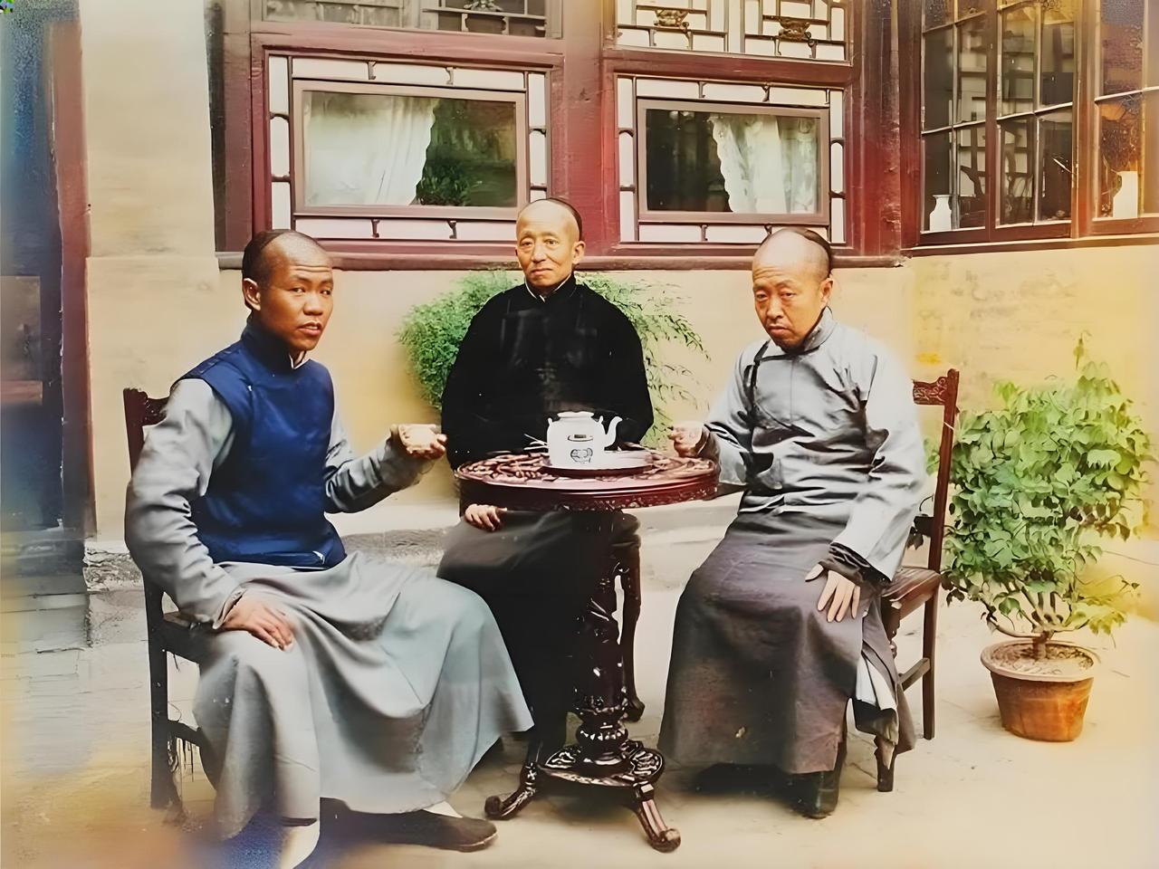清末的一处四合院院落里，三位男子围坐在一张小巧的圆桌旁喝茶。他们身着传统的长衫、