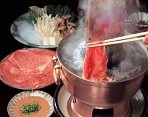 火锅里的红油亮得诱人，旁边摆着码得整整齐齐的食材：嫩红色的羊肉卷肥瘦相间，稍微一