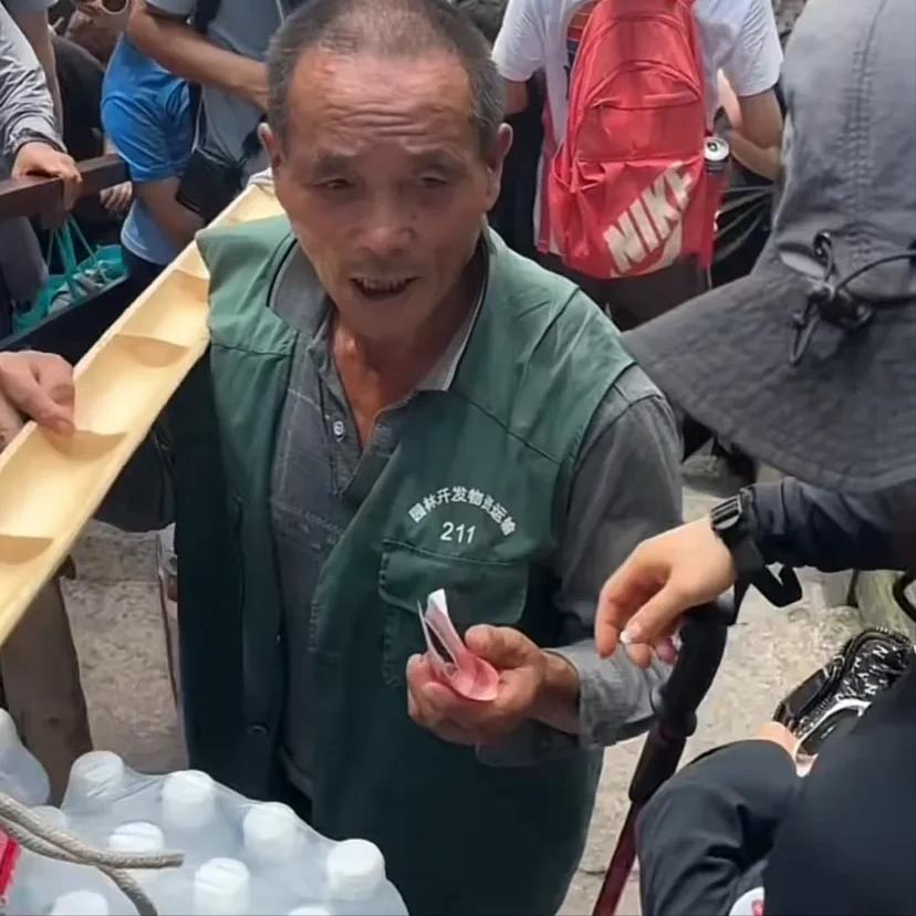 8月17日，安徽黄山，一年轻的女子在下山时，给遇见的每一位挑山工每人发一百块，随