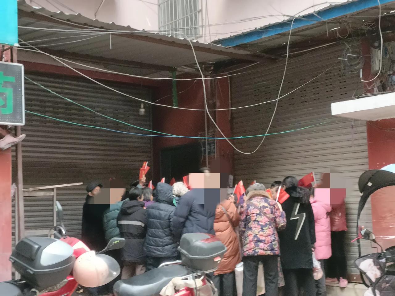 快来拿“趴活”了！沈家坝一市场的角落处，一大群老年人手举小国旗，不知道的还以为是
