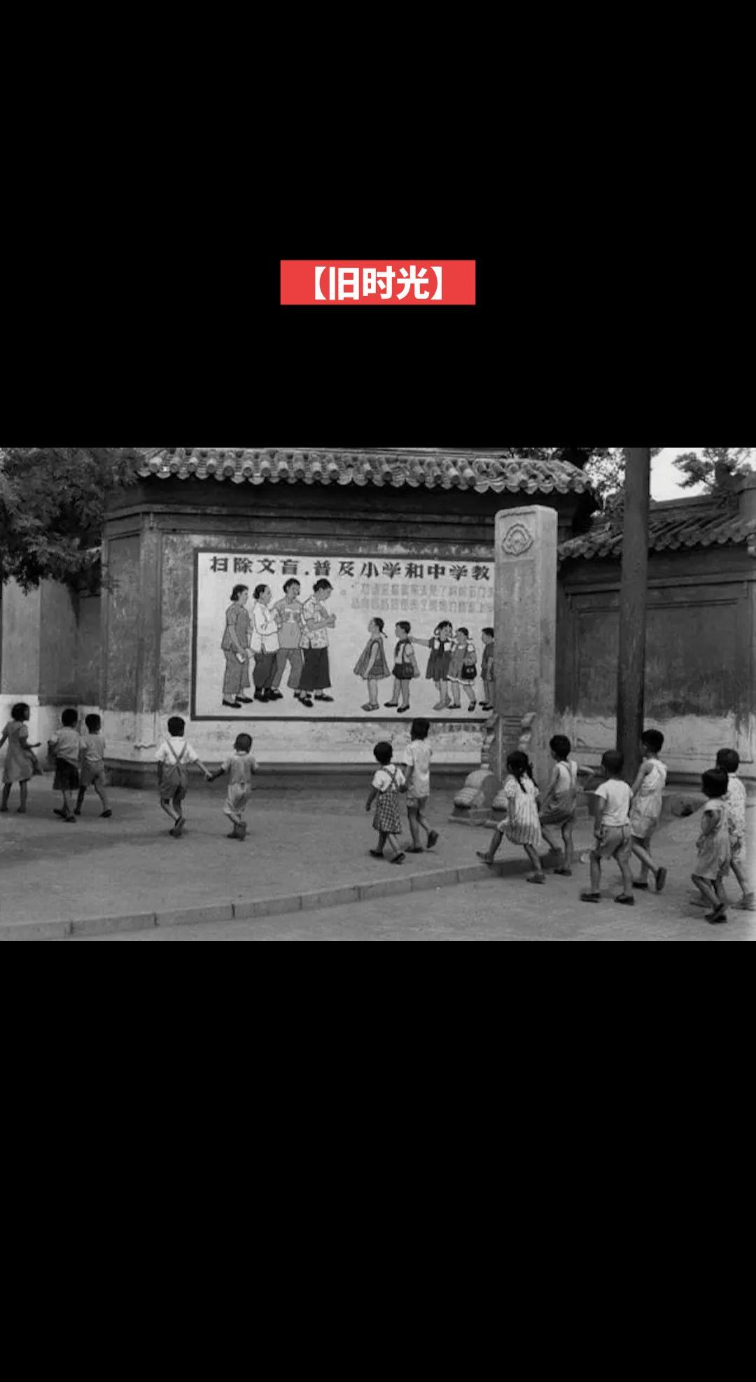 【旧时光】一队儿童走过城市宣传扫除文盲的宣传画标语
(1958年)