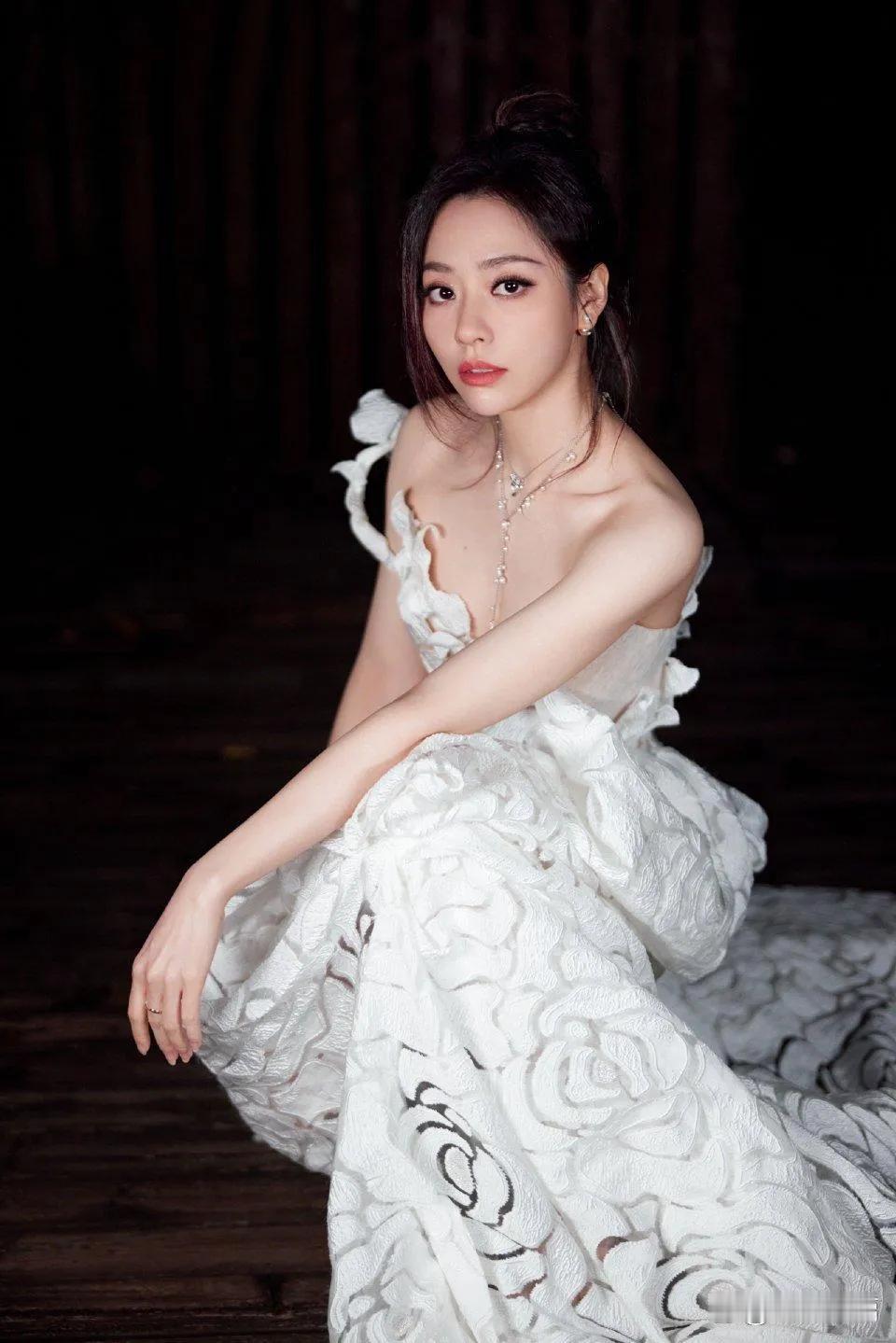 张靓颖白玫瑰绽放于裙摆，描绘动人之姿。