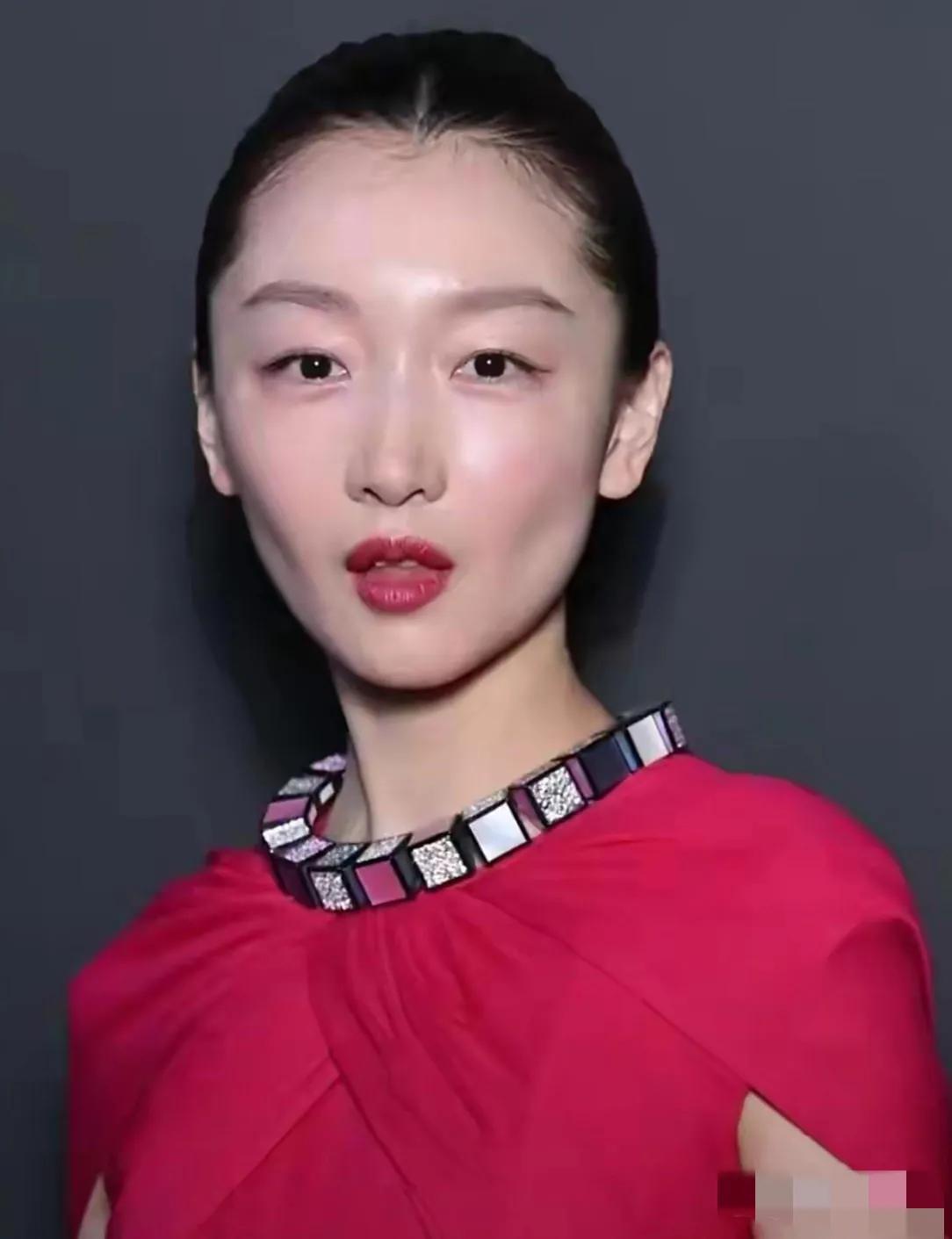 镜头中的周冬雨发型利落，黛眉如画，皮肤润泽，朱唇粉面，但面颊塌陷，唇若香肠，脖颈