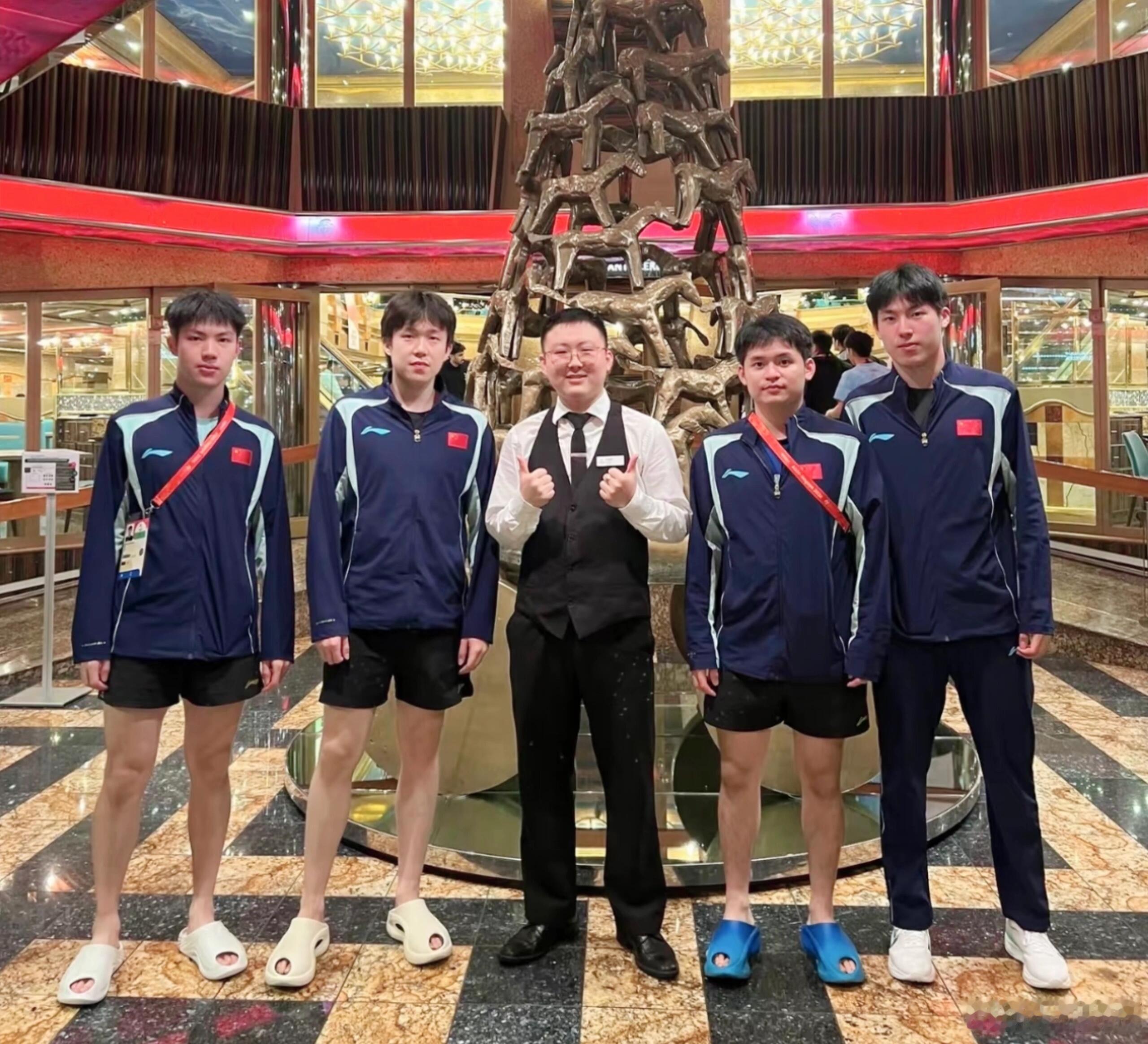 邮轮大堂抓拍名场面，王楚钦领衔男队队友出镜。抛开竞技场上的胜负，他们也只是一群朝