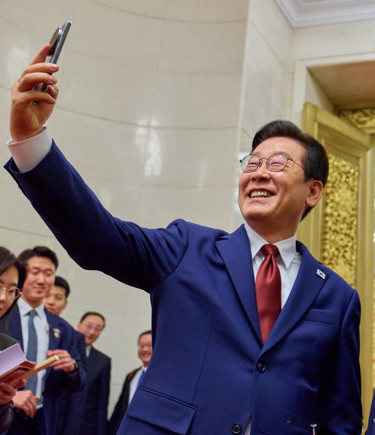 李在明用庆州收到的小米手机在人民大会堂自拍，人情世故这一块……都是细节！