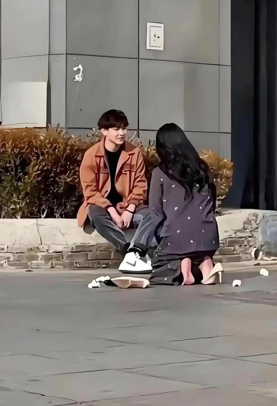 路人拍摄到一对小两口产生情感龃龉的画面。只见女生双膝跪地，一只高跟鞋丢在一旁，她