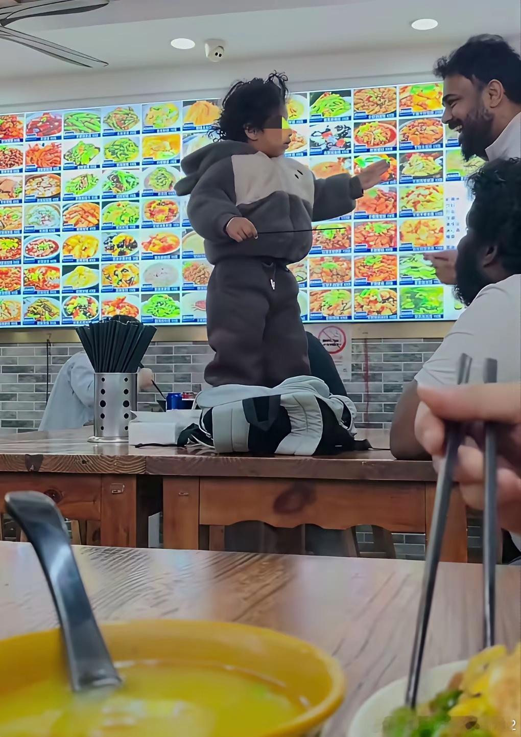 看到这样一幕，确实感觉如鲠在喉！看饭店墙上的菜谱，大厅里的座椅，应该是我们国内的