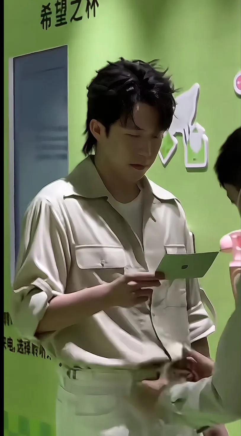 在希望之杯的现场，他手持卡片，专注而坚定。〈楚钦穿什么都好看〉