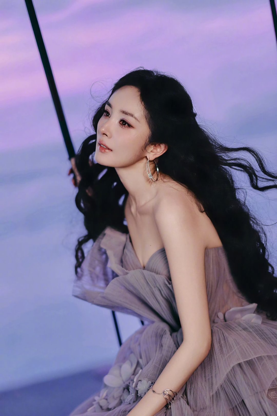 杨幂藕粉色抹胸纱裙藕粉色纱裙搭配复古羊毛卷，杨幂演绎独有的法式浪漫。柔光烘托出裙